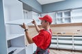 Kitchen installation. Worker assembling furniture