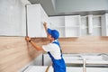 Kitchen installation. Worker assembling furniture