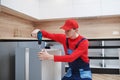 Kitchen installation. Worker assembling furniture