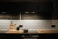 Kitchen interier. black cabinets, white tiles. the pan is on the stove. Scandinavian style kitchen