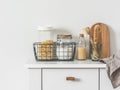 Kitchen interior - cans of pasta, flour in a metal basket, dishwashers, cutting boards, napkin on a white table