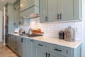 Kitchen interior with cooktop on white counter top under hanging cabinets