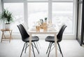 Kitchen interior - white table with crockery and black chairs Royalty Free Stock Photo