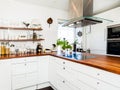 Kitchen interior with wooden kitchen counter-top and white cupboards