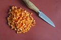 Kitchen knife with wooden handle and shredded raw carrots on red Royalty Free Stock Photo