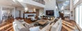 a kitchen and living room with wooden accents, featuring a panoramic view that includes stairs ascending to the second Royalty Free Stock Photo