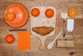 Kitchen mock up. Orange: mandarin, plate, pencil, notebook, on a wooden surface.