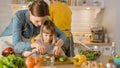 In Kitchen: Mother and Cute Little Daughter Cooking Together Healthy Dinner. Mom Teaches Little Gi Royalty Free Stock Photo