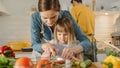 In Kitchen: Mother, Cute Little Daughter Cooking Together Healthy Dinner. Mother Teaches Little Gi Royalty Free Stock Photo
