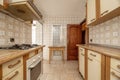 Kitchen with old wooden furniture on both sides of the wall and kitsch vintage