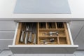 Kitchen utensils in drawer. Forks, spoons and knives.