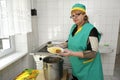 At the kitchen, preparing food. Cook keeping plate with ready meal in hands