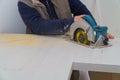 Contractor using electric saw to cut through a laminate kitchen formica counter top. Focus on saw Royalty Free Stock Photo