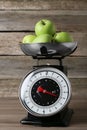 Kitchen scale with green apples on wooden table Royalty Free Stock Photo