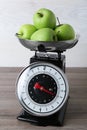 Kitchen scale with green apples on wooden table Royalty Free Stock Photo