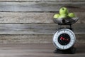 Kitchen scale with green apples on wooden table. Space for text Royalty Free Stock Photo