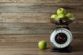 Kitchen scale with green apples on wooden table. Space for text Royalty Free Stock Photo