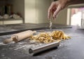 Kitchen scene with homemade pasta and a hand dropping flour