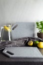 Kitchen setup with gray stone cutting boards, lemons and limes, glass pitcher with beverage like lemonade or mojito