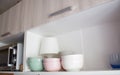 kitchen shelf with utensils. Ceramic plates in pastel shades, pink, olive