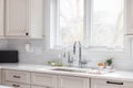 A kitchen sink detail with tan cabinets and white subway tile backsplash. Royalty Free Stock Photo