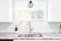 A kitchen sink detail with white cabinets and subway tile backsplash. Royalty Free Stock Photo