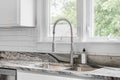 A kitchen sink detail in a white kitchen with subway tiles. Royalty Free Stock Photo