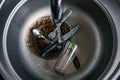 Kitchen sink with dirty pots, flowing tap