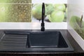 Kitchen sink and faucet installation. The black sink and faucet are built into the black countertop. Repair in the house Royalty Free Stock Photo