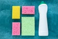 Kitchen sponges and antibacterial cleaner in bottle, disinfection concept. Housekeeping, housework. Colorful sponges for washing