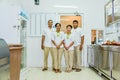 Kitchen staff team in uniform smiling with trays in the kitchen