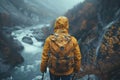 A backpacker walking by water surrounded by mountain landscape Royalty Free Stock Photo