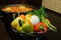 Kitchen still-life. Fresh raw vegetables and a boiling cauldron with appetizing supper meal on the electric stove. Fresh vegetable