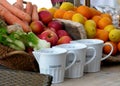 Kitchen still life with fruits and vegetables and white porcelain measuring cups Royalty Free Stock Photo