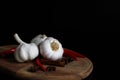 Kitchen still life with raw garlic bulbs, red chilli, cinnamon sticks and anise stars spice on wooden chopping board Royalty Free Stock Photo