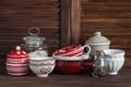 Kitchen still life. Vintage crockery - jar of flour, ceramic bowls, pan, enamelled jar, gravy boat. On a dark brown wooden table Royalty Free Stock Photo
