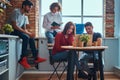 Kitchen in student dormitory. Group of interracial students engaged in education. Royalty Free Stock Photo
