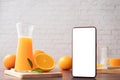 Kitchen table with Blank screen smart phone, cell phone, tablet and jug of orange juice