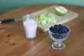 Kitchen table. A bowl of blueberries, a glass of yogurt Royalty Free Stock Photo