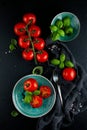 Kitchen table decorated with fresh tomatoes, basil and salt and pepper with fork and napkin Royalty Free Stock Photo