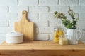 Kitchen table with food jars and plants over white brick wall background. Kitchen mock up for design and product display Royalty Free Stock Photo