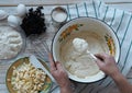 Kitchen table with ingredients for making semolina pie.Hands of an elderly woman kneading dough.Food pastry background. Royalty Free Stock Photo