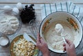 Kitchen table with ingredients for making semolina pie.Hands of an elderly woman kneading dough.Food pastry background Royalty Free Stock Photo