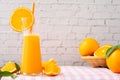 Kitchen table with jug of orange juice and orange fruit in basket on white brick wall texture background Royalty Free Stock Photo