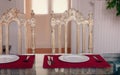 The kitchen table porcelain plates fork , knife , and two vintage chair against the window