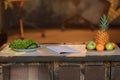 Kitchen table setup. Blank notebook and fruits side view Royalty Free Stock Photo
