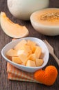 Kitchen table with slice fresh cantaloupe melon on white plate Royalty Free Stock Photo