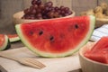 Kitchen table with Sliced of Watermelon on cutting board and grape fruit. Royalty Free Stock Photo