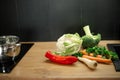 Kitchen tabletop with pile of fresh ripe vegetables. Tasty bell pepper, broccoli, carrots, greens, cauliflower. Royalty Free Stock Photo