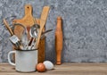 Kitchen tools for cooking on a wooden table on the background of a concrete wall. Royalty Free Stock Photo